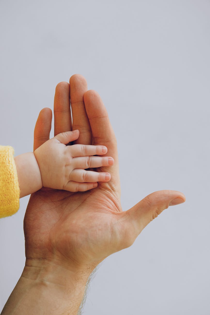 O que é Paternar? father and baby hands together