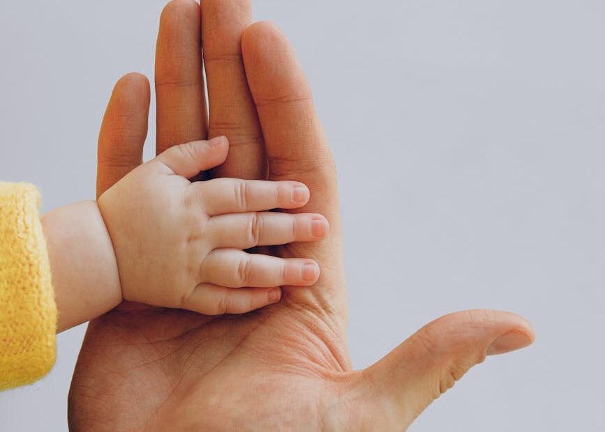 father and baby hands together