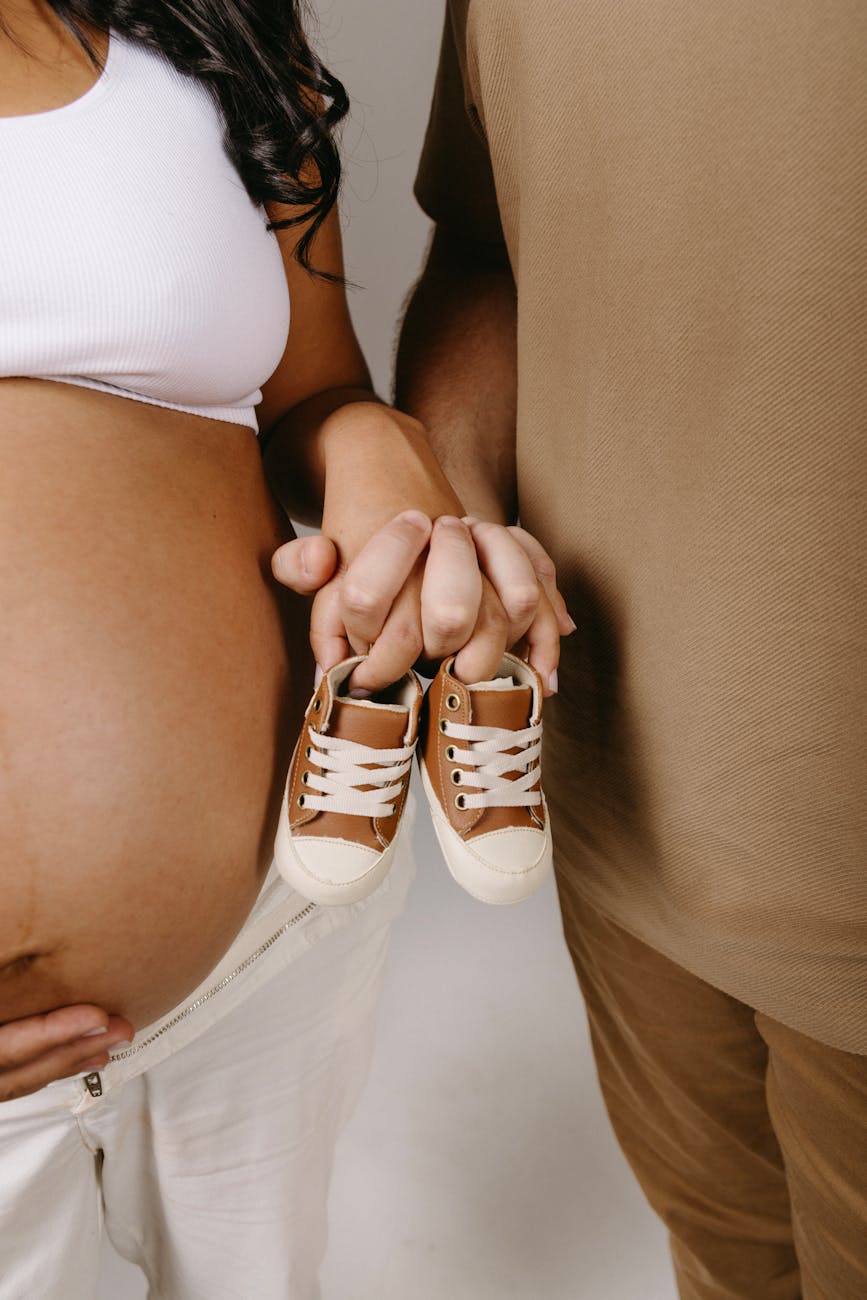 10 Melhores dicas para pais de primeira viagem couple expecting a baby posing in a studio